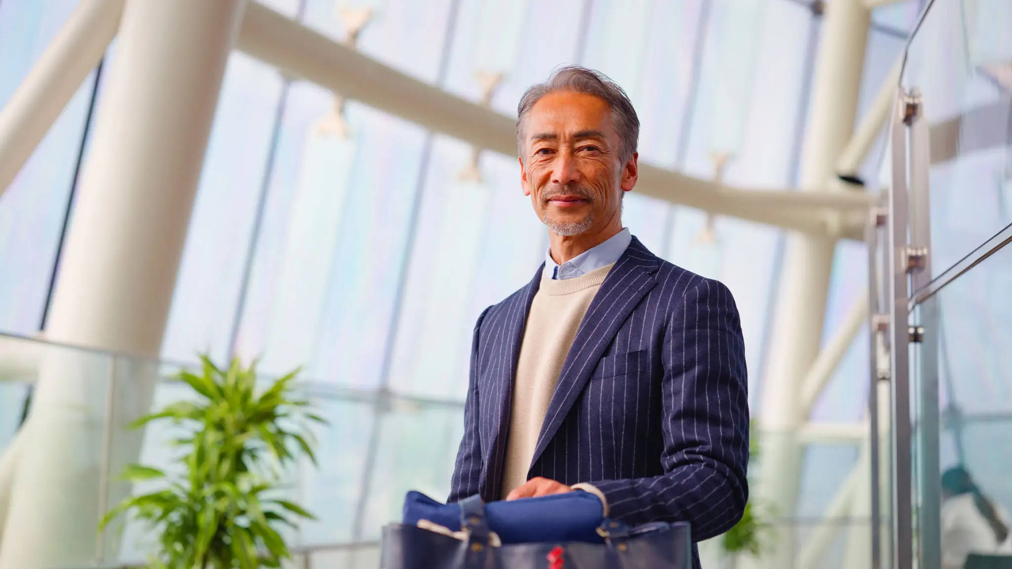 Man in striped suit holding a bag.
