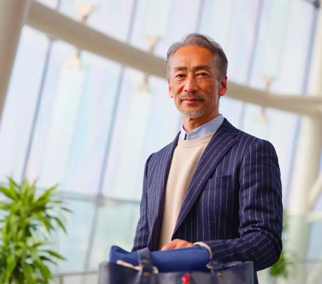 Man in suit holding a bag indoors.
